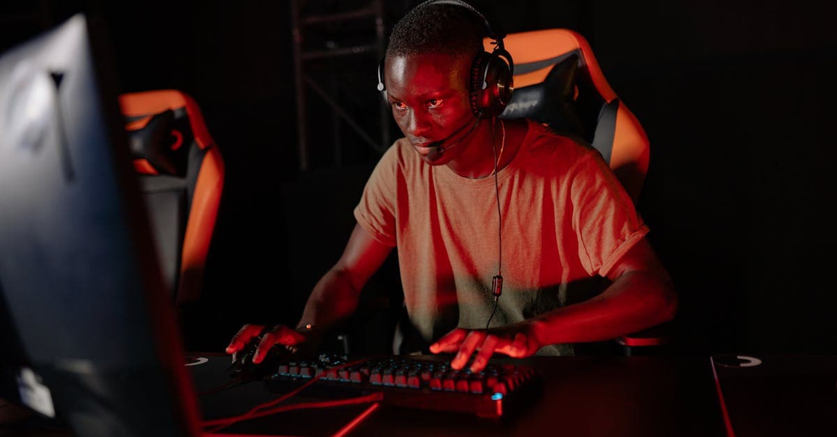 Focused gamer playing online with headset and red lighting environment.