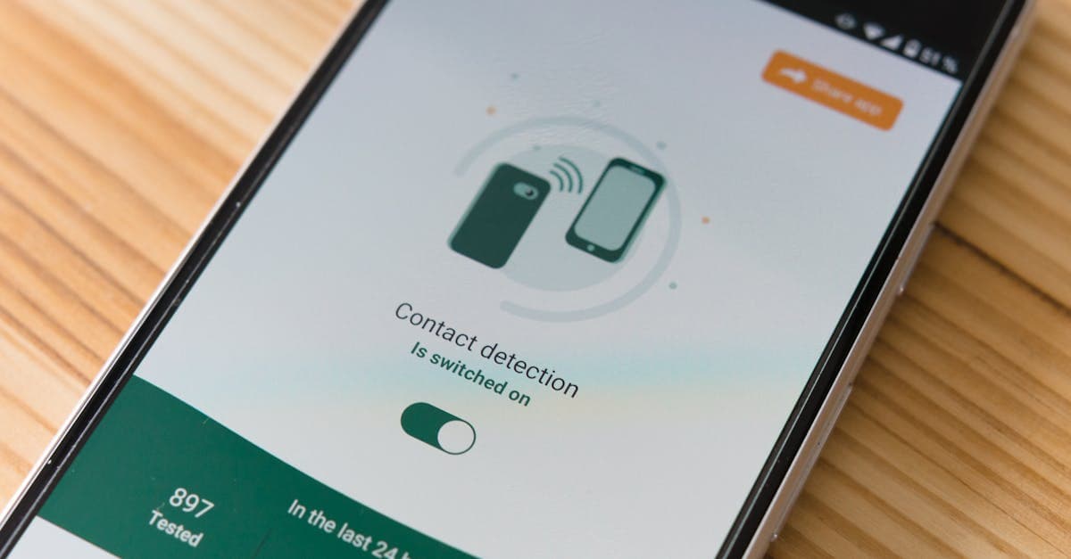 Close-up of smartphone displaying contact detection app on wooden surface.