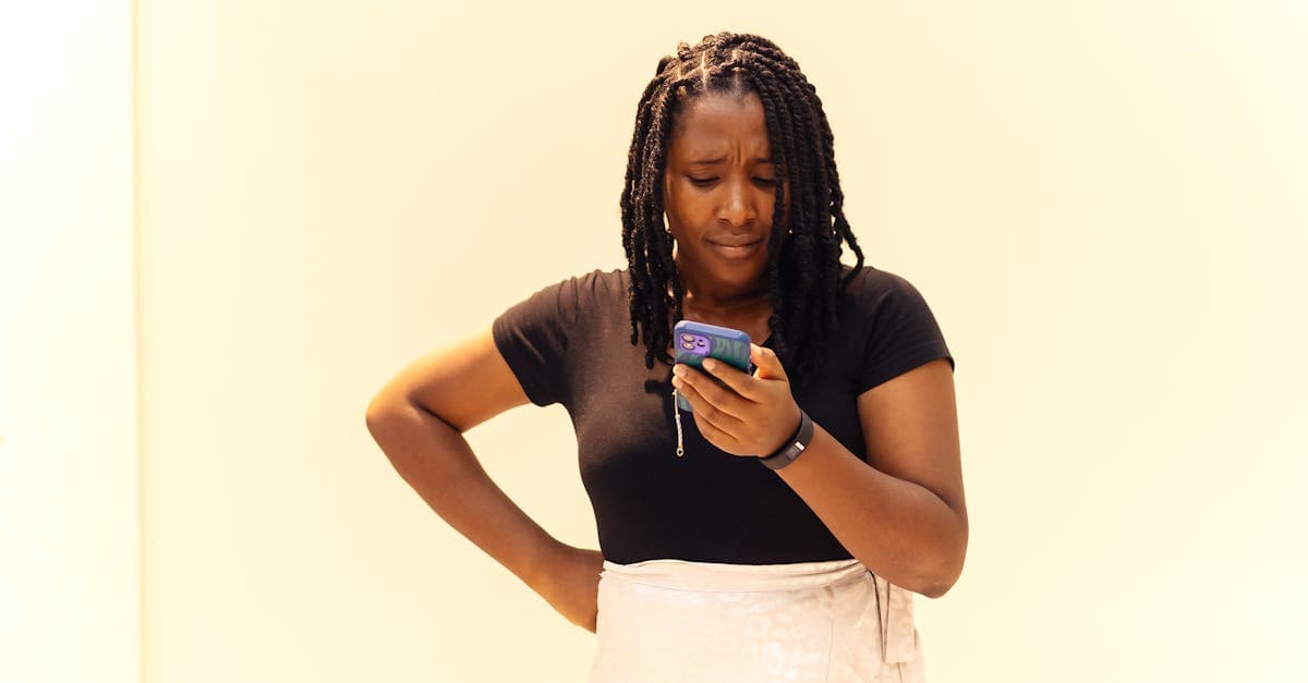 A young woman with braids looks at her phone in Lagos, Nigeria.
