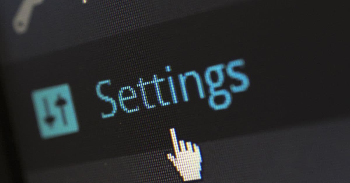 A close-up photo of a computer screen showing the settings button with a cursor hovering over it.