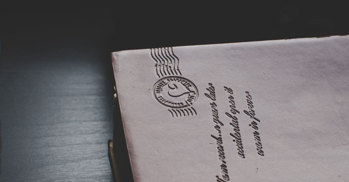 Close-up of a vintage envelope with postal markings on a dark wooden surface.