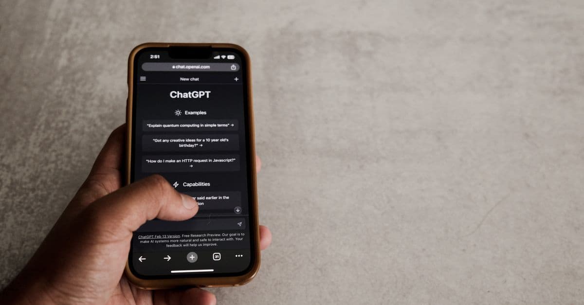 Close-up of a hand interacting with ChatGPT on a smartphone, showcasing modern AI technology.