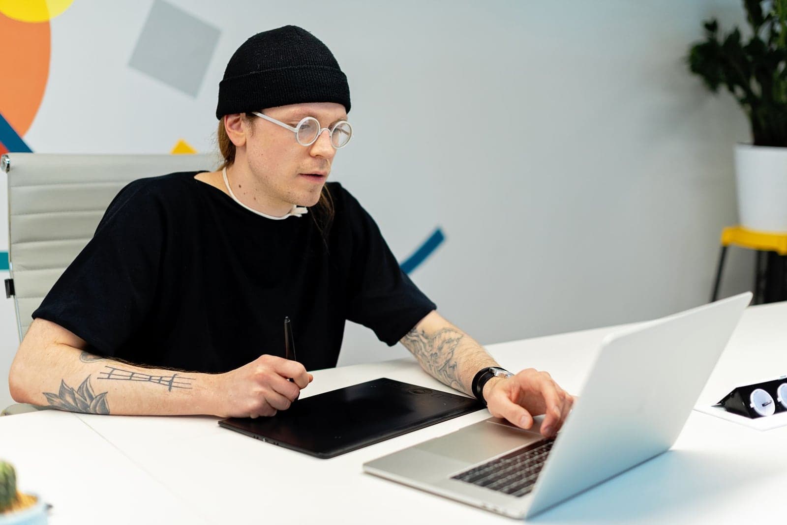 Designer working on a laptop and tablet in an office