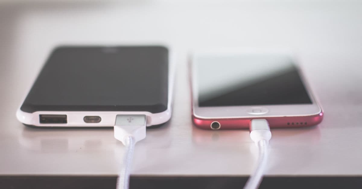 Two smartphones charging side by side on a desk. Modern and technological setting.