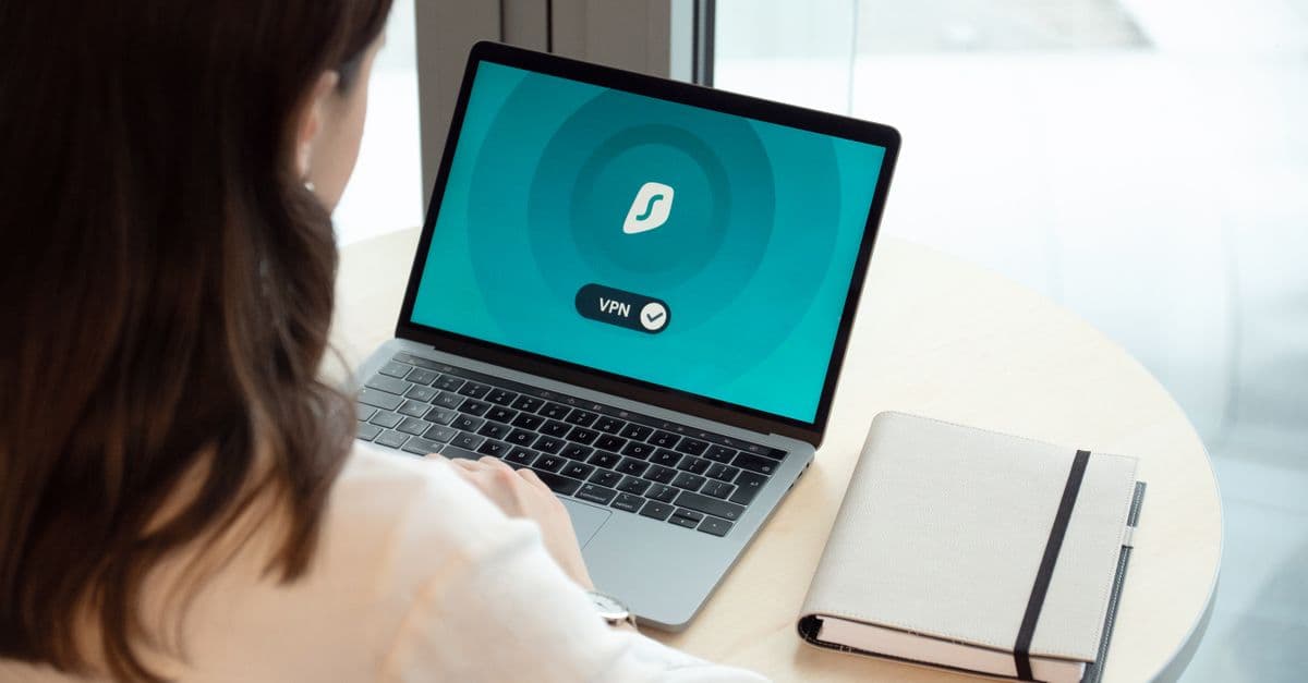 A woman working on a laptop with a VPN icon on screen for secure online browsing.