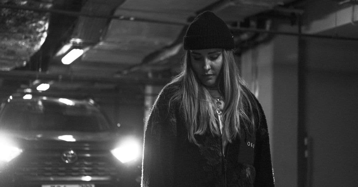 Emotional black and white portrait of a woman in an underground parking garage.