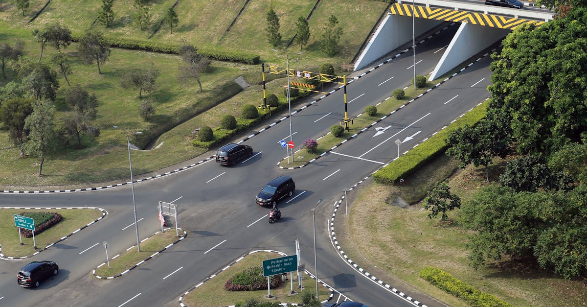Aerial photo showcasing a busy intersection with cars and greenery, highlighting urban infrastructure and transportation.