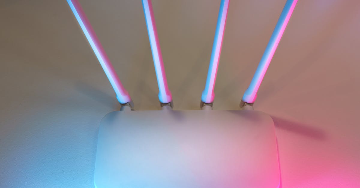 Sleek white wireless router with four antennas emitting soft blue and pink light.
