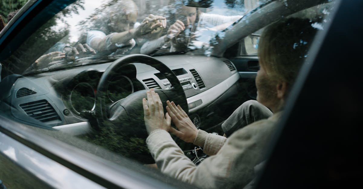 Intense moment of zombies attacking a car windshield in a suspenseful setting.