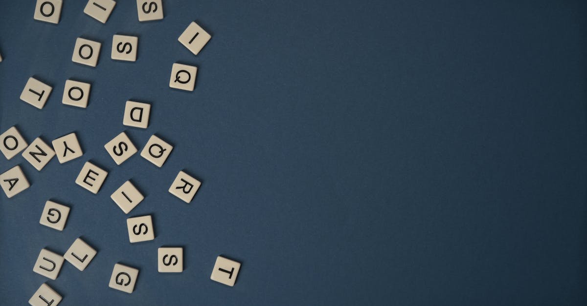 Scrabble tiles scattered on a blue background with ample copy space.