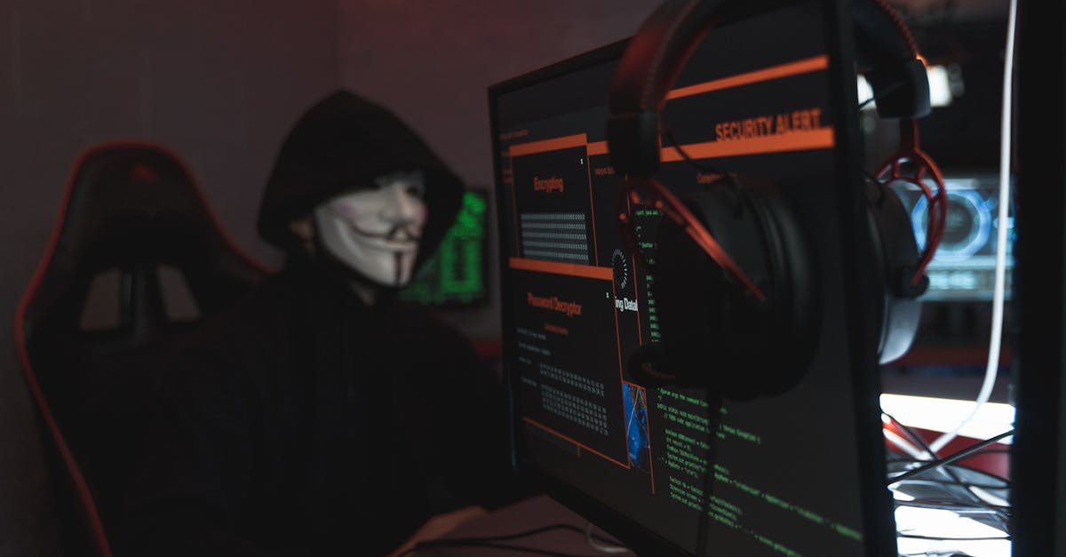 A person wearing a Guy Fawkes mask engaged in hacking activities on a computer in a dimly lit room.