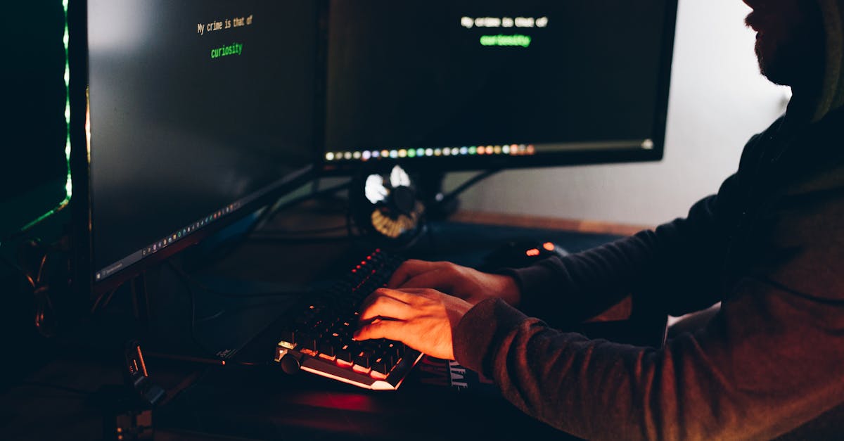 Silhouette of a person typing on a computer in a dimly lit room, emphasizing cybersecurity threats.