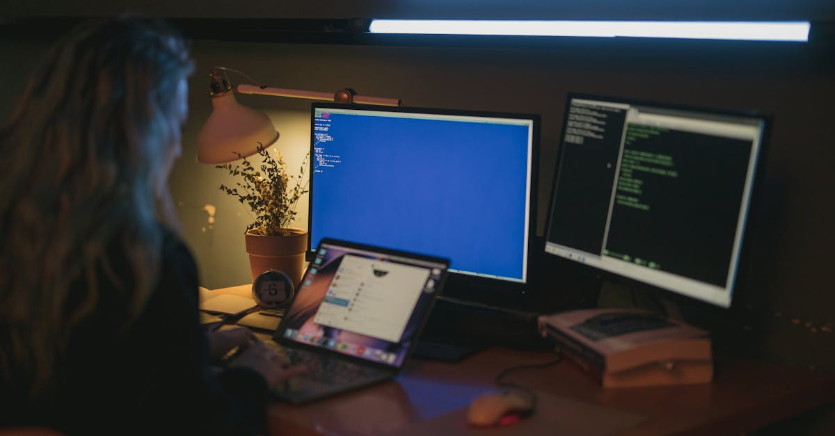 Woman using multiple screens for cybersecurity tasks in a cozy home office