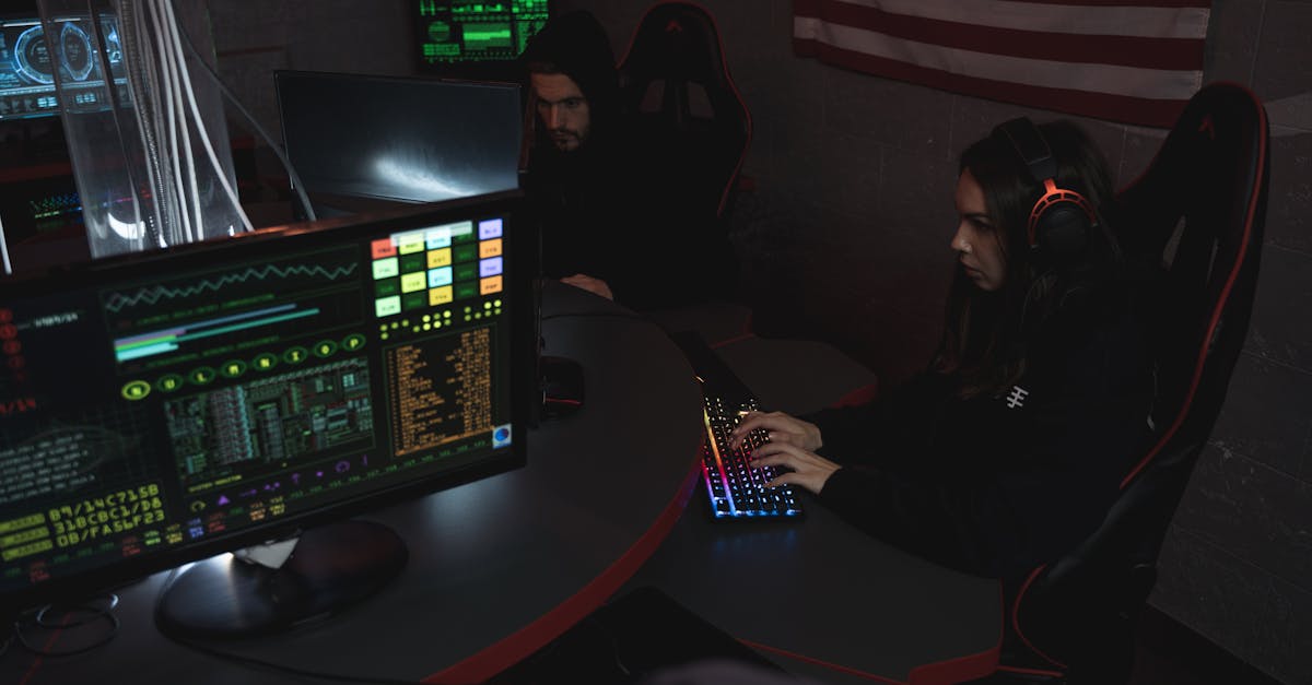 Cybersecurity professionals working on computer systems, focusing on data protection in a dimly lit room.
