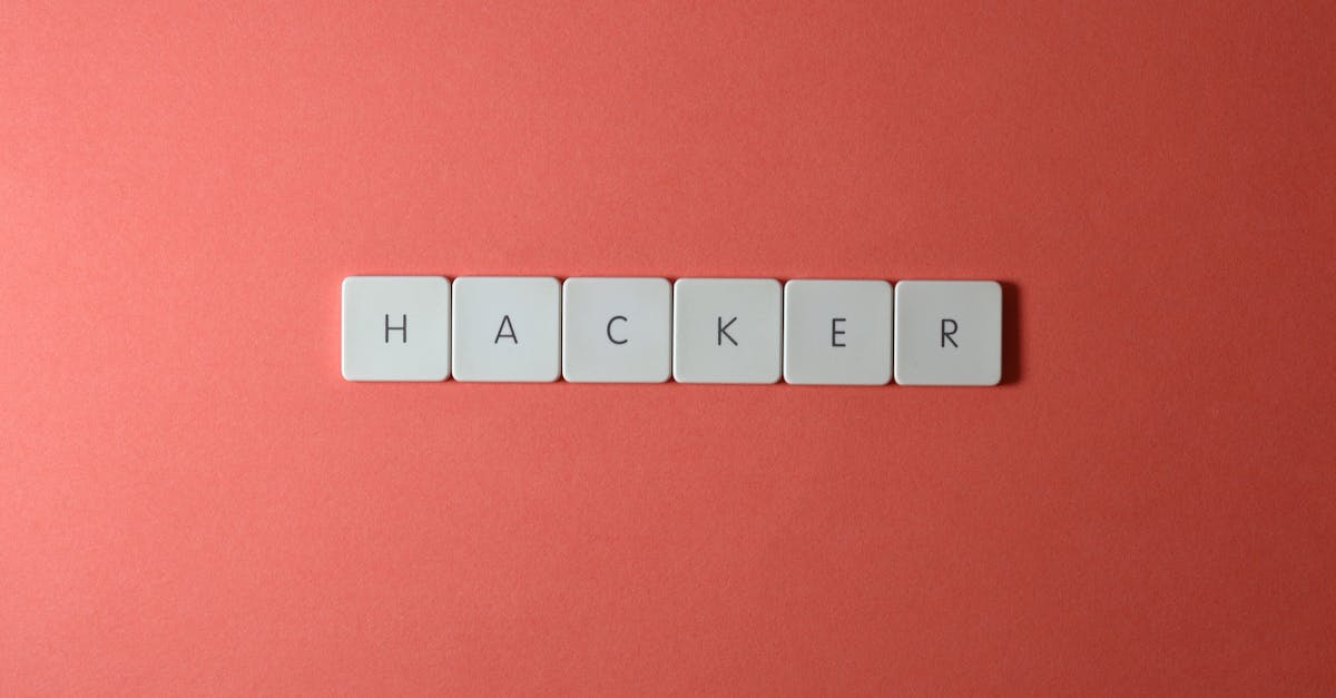 Close-up of the word 'HACKER' made with letter tiles on a red background, emphasizing cybersecurity.