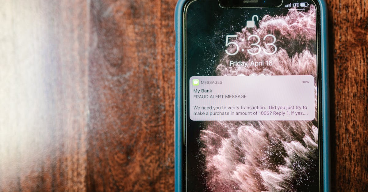 Close-up of a smartphone displaying a fraud alert notification on a wooden surface.