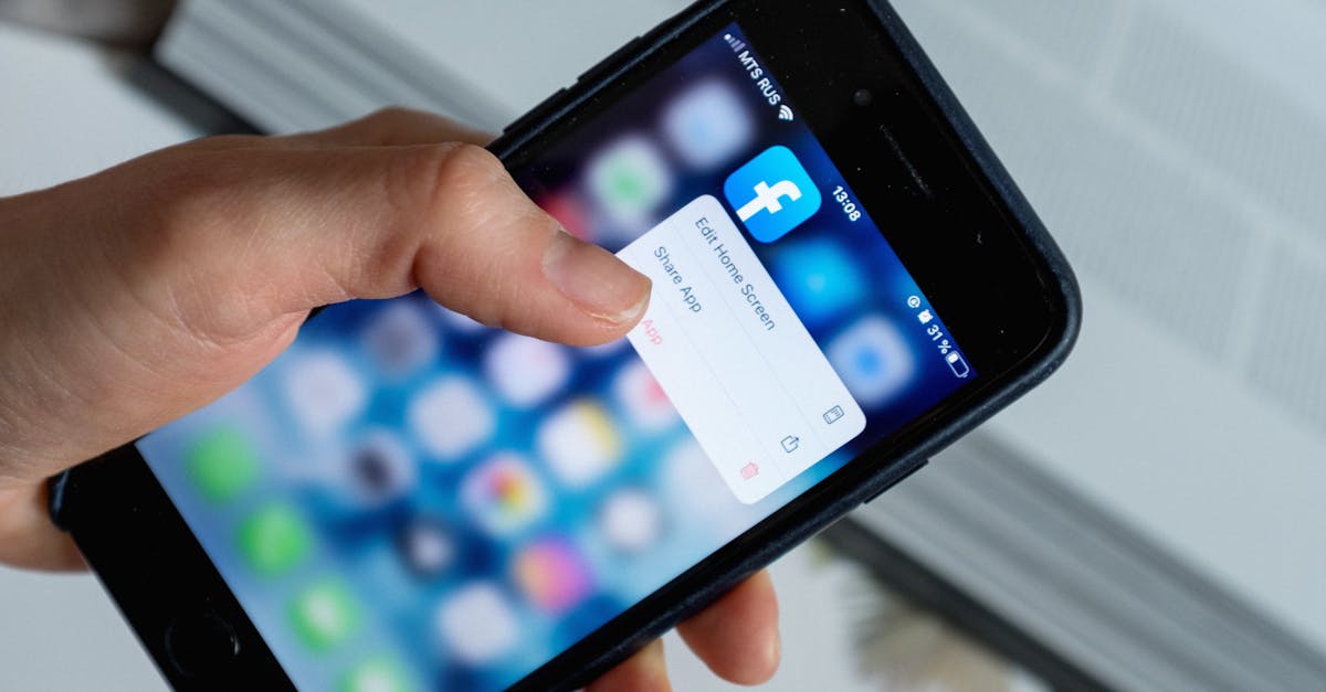 From above of crop anonymous person touching blurred cellphone screen while opening app and choosing option from pop up window