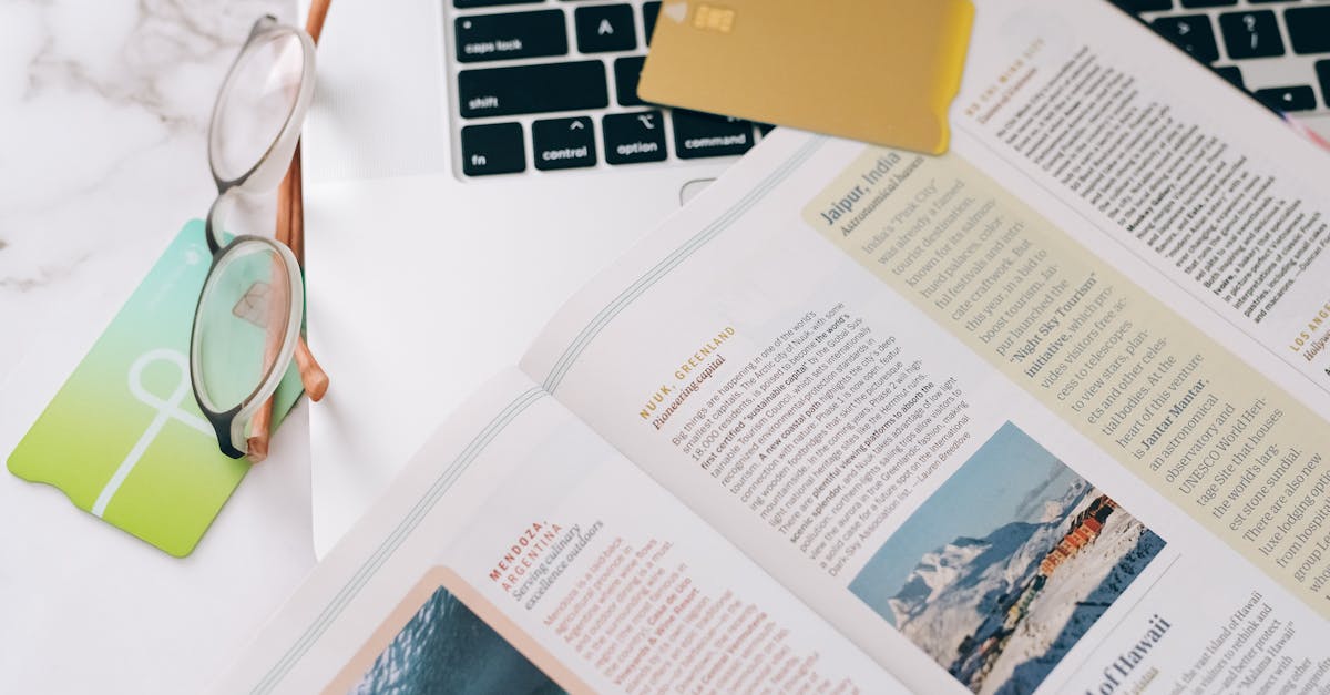 Close-up of a book, glasses, and laptop on a desk, ideal for education or productivity concepts.