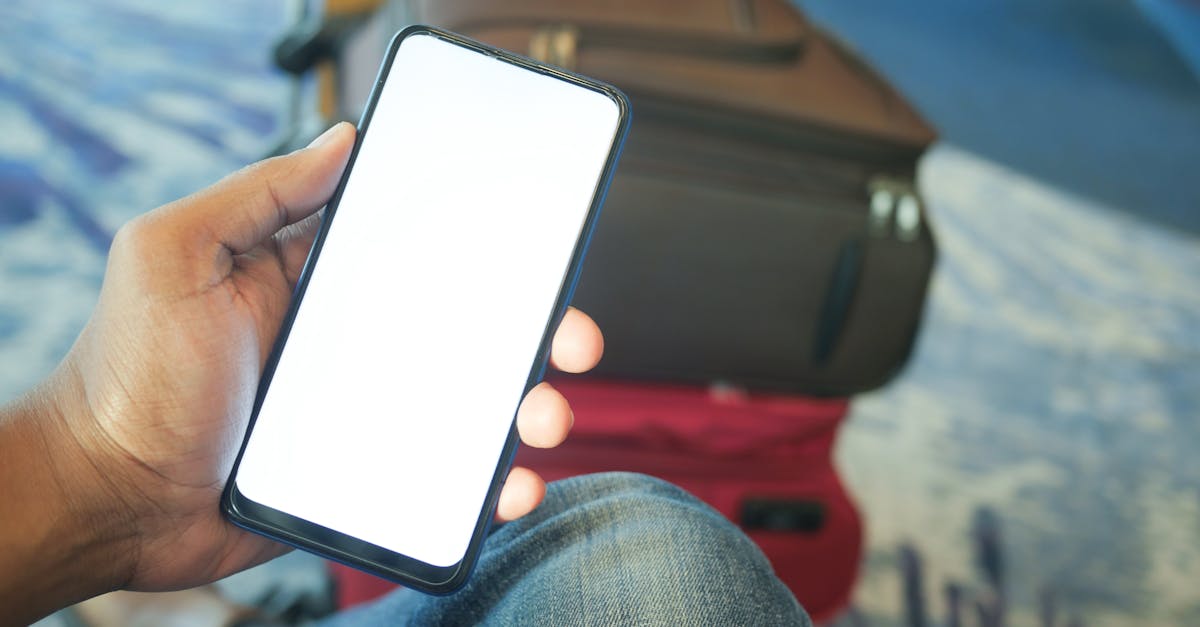 A person holding a smartphone in an airport with luggage visible, ideal for travel and tech concepts.