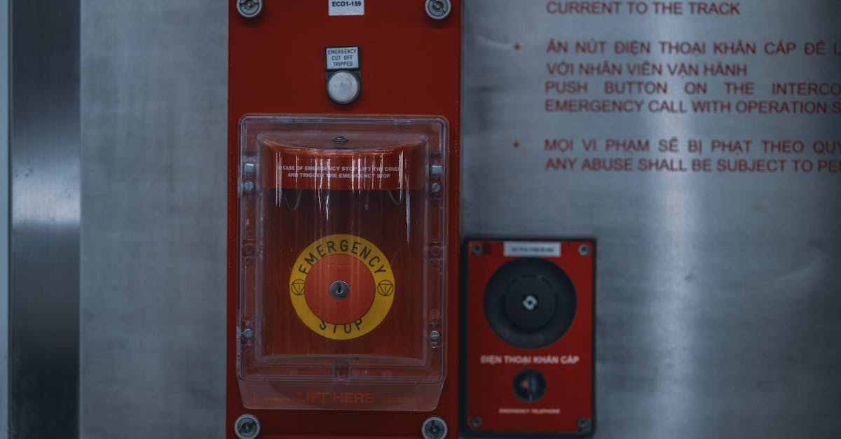 Close-up of an emergency stop button with warning text on an industrial panel.