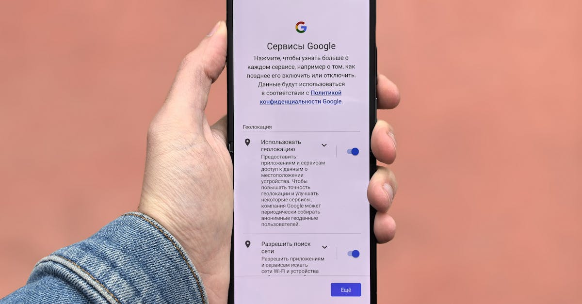 A person holding a smartphone displaying Google settings on a simple background.