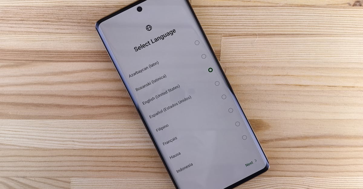 Close-up of smartphone with language selection screen on wooden table.