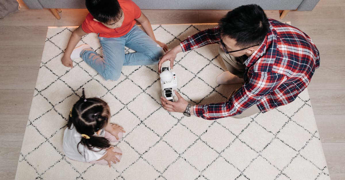 A father and his two children enjoying playtime with a toy robot in the living room.