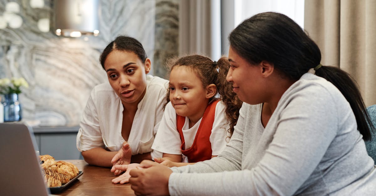 A family enjoying time together watching a video on a laptop indoors.