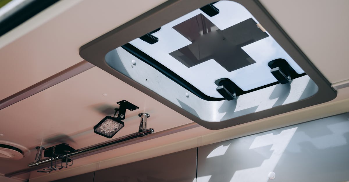 View of an ambulance's roof window featuring a medical cross symbol and ceiling equipment.