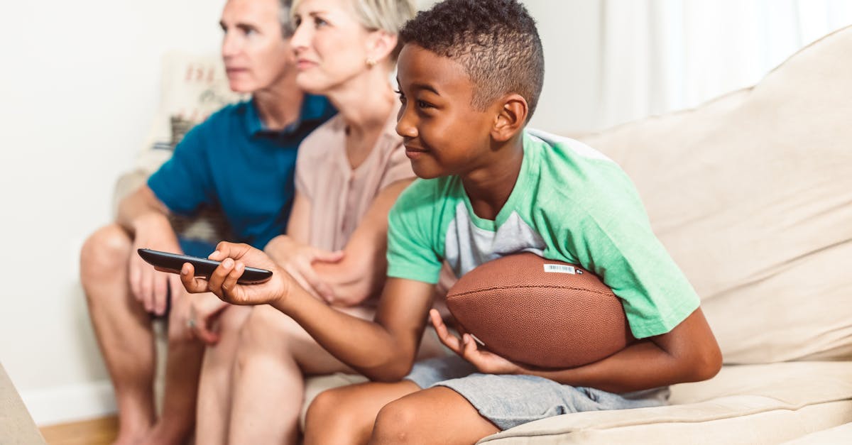 Happy family sitting on a couch watching TV, enjoying bonding time.