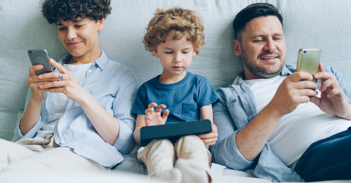 Happy family enjoying screen time together on a cozy couch at home.