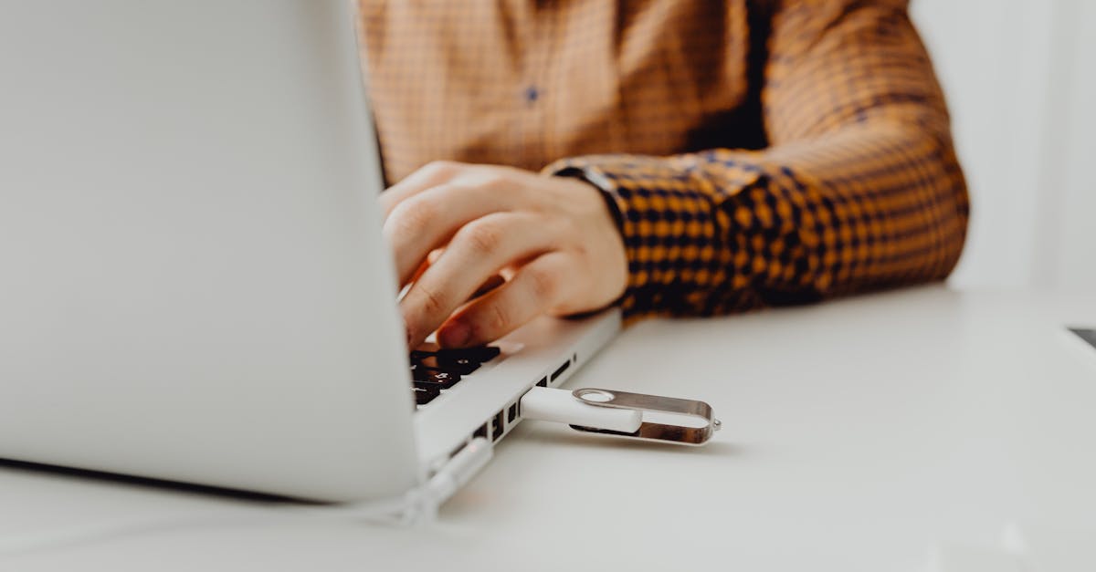 A person working on a laptop with a USB flash drive connected, representing technology and data storage.