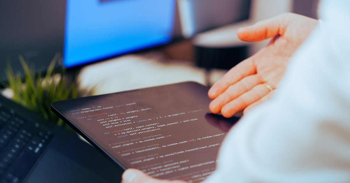 Software developer analyzing code on a tablet in a modern office workspace.
