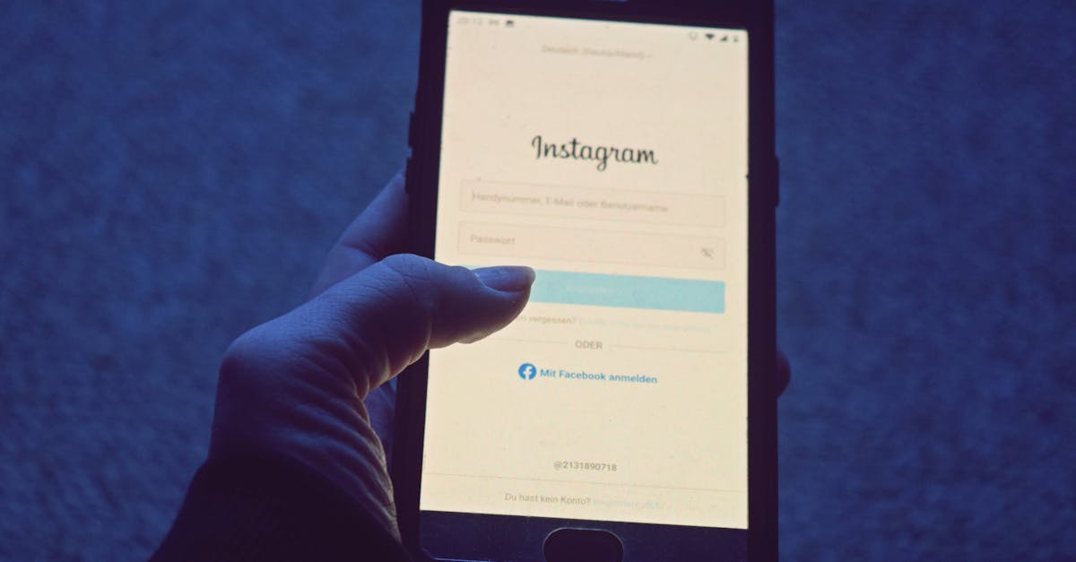 Close-up of a hand holding a smartphone displaying the Instagram login screen.