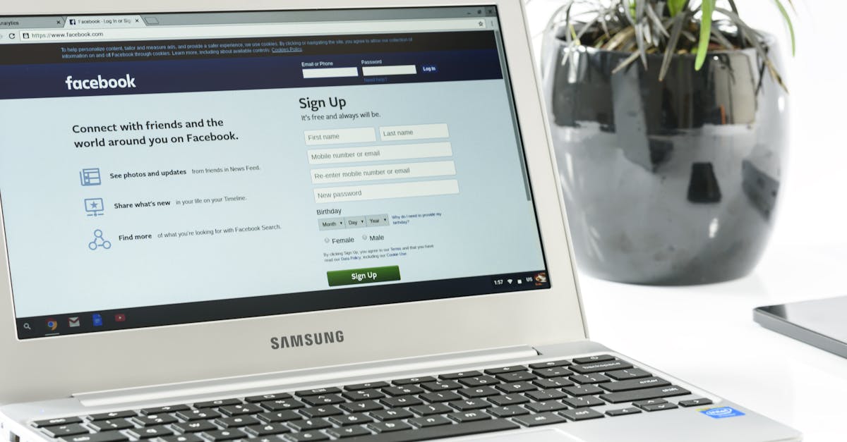 Open Samsung laptop showing Facebook sign-up page next to a potted plant. Ideal for technology themes.