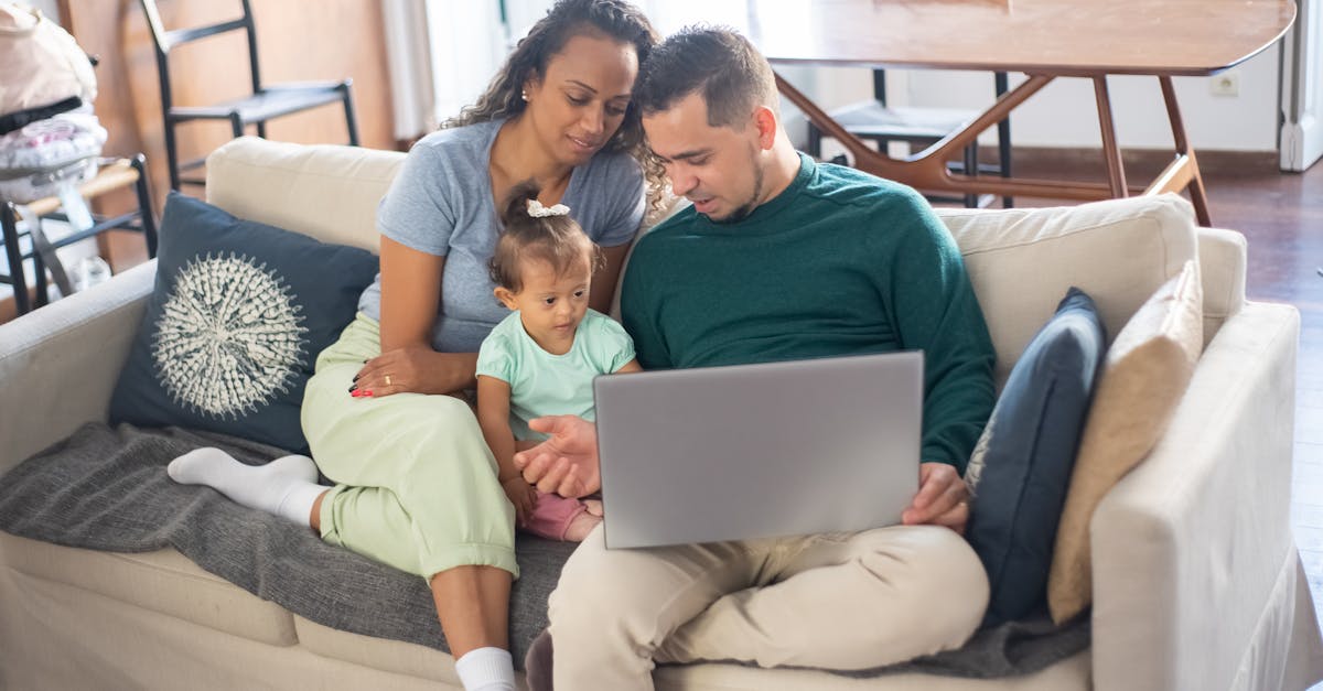 A family spending quality time together on a sofa, engaging with a laptop.