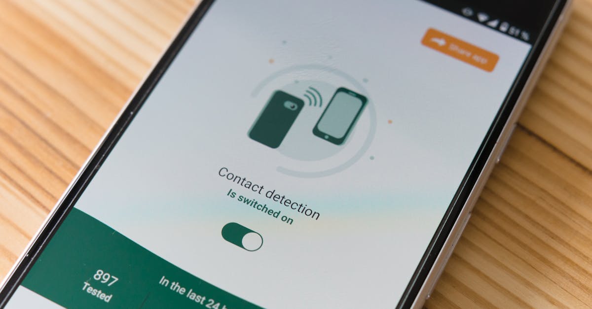 Close-up of smartphone displaying contact detection app on wooden surface.