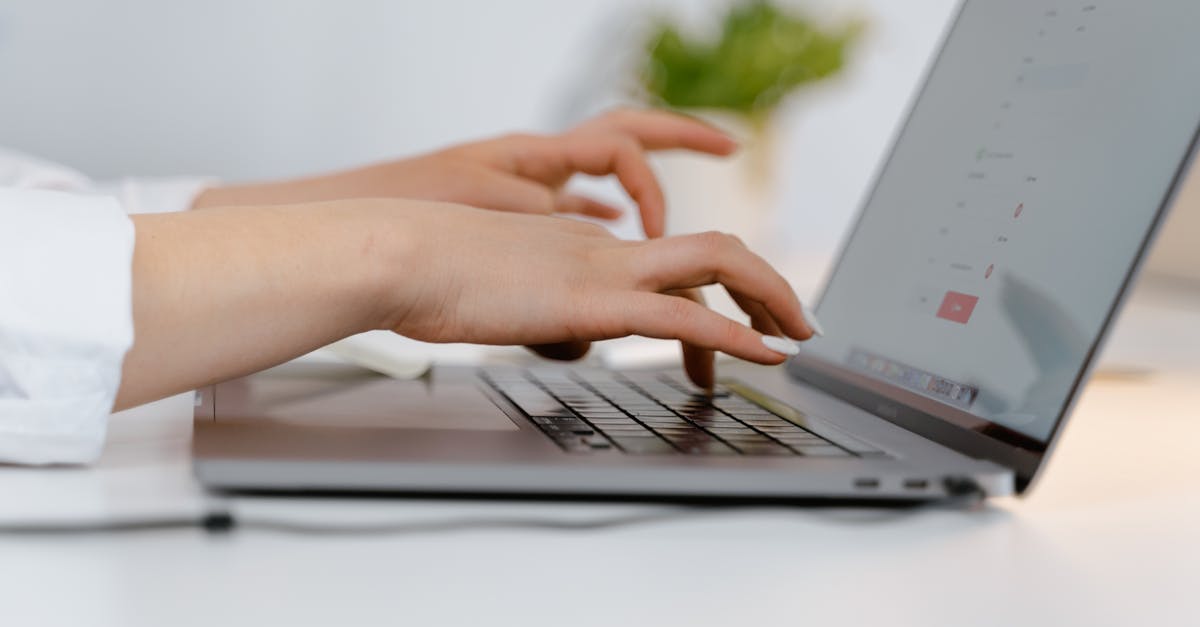 Hands typing on a laptop keyboard, ideal for concepts of remote work and technology.