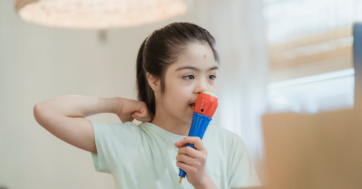 A young girl enthusiastically playing with a colorful toy microphone indoors, expressing joy and creativity.