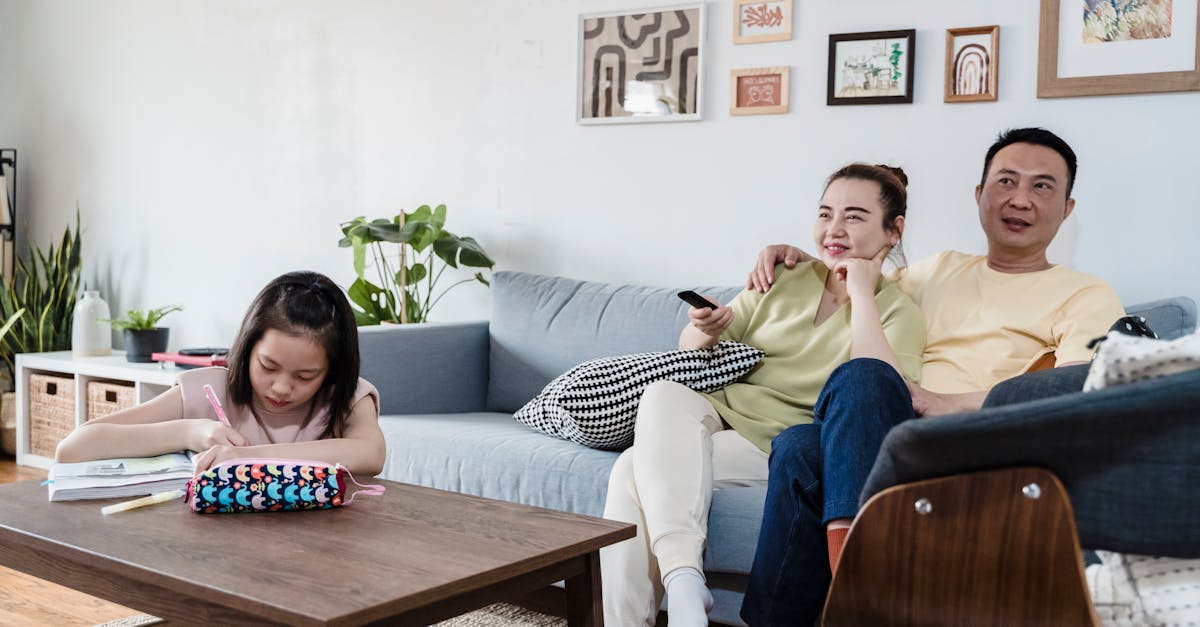 A family enjoying leisure time at home, with a child studying and parents relaxing on the couch.