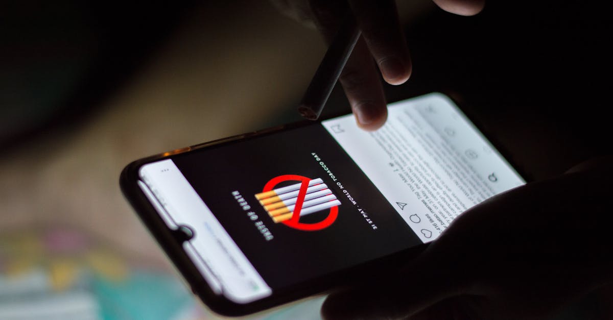 A person browsing social media on a smartphone at night, holding a cigarette.