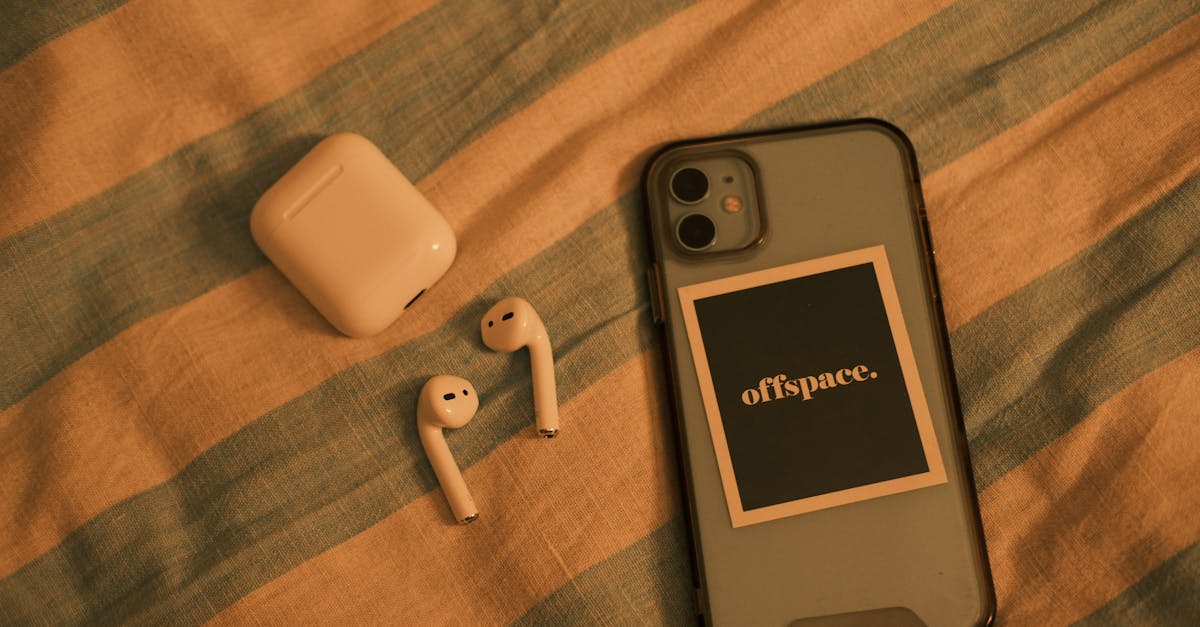 Close-up view of a smartphone and wireless earbuds on a striped fabric background.